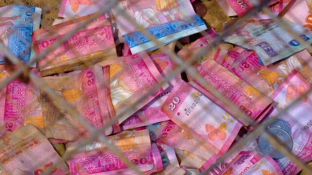 Closeup Sri Lankan currency notes and coins money in donation box of temple in Sri Lanka