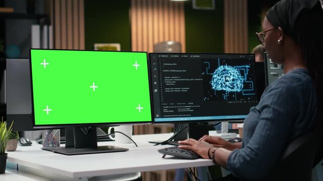 Green screen mockup PC used by tech agency admin using AI to optimize software in office late at night. IT professional at work using deep learning on chroma key computer to do debugging.