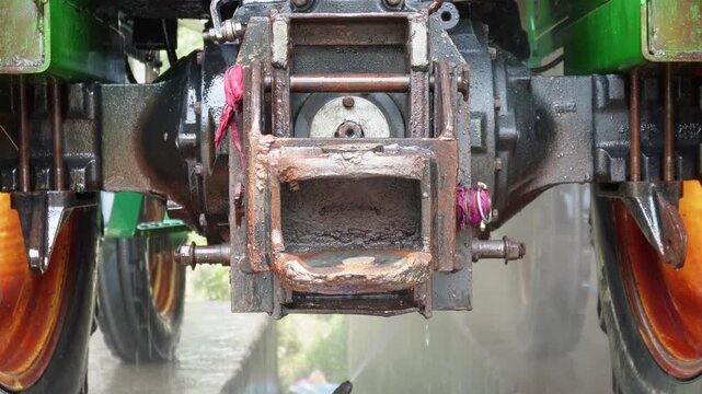 Worker washing tractor with care