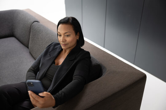 Engaged woman using smartphone in modern setting
