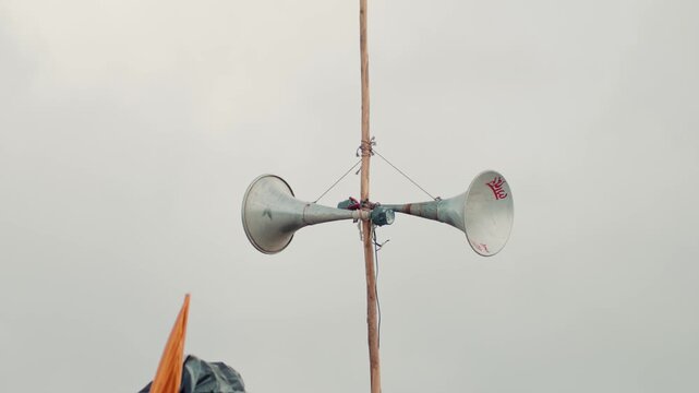High-quality 4K footage of a public address loudspeaker mounted on a pole against a bright sky. Ideal for concepts including community communication, public announcements, emergency alerts