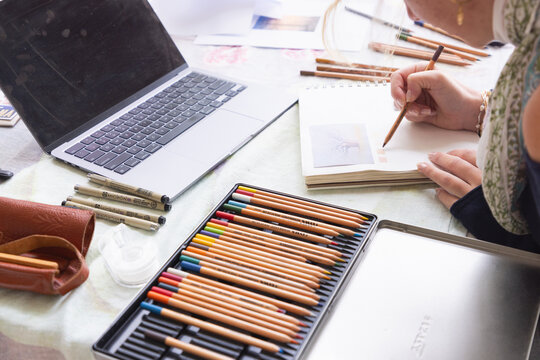 20 year old woman artist working on a drawing in her studio