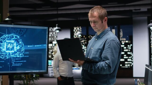 Software developer in office using laptop, working to fix bugs in AI system with debugging and troubleshooting context for AI development workflow.