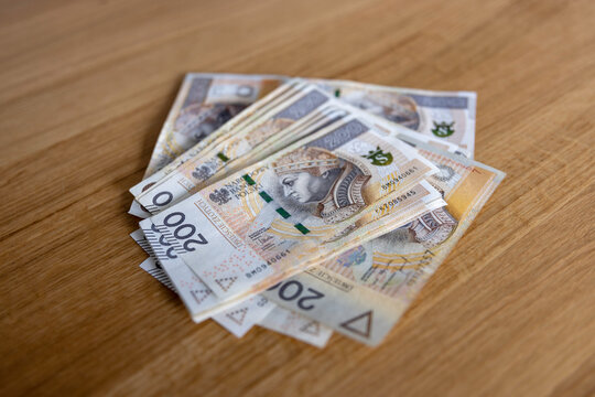 Plik banknot&oacute;w 200 złotych na dębowym stole &mdash; got&oacute;wka, bogactwo, wypłata, Polska