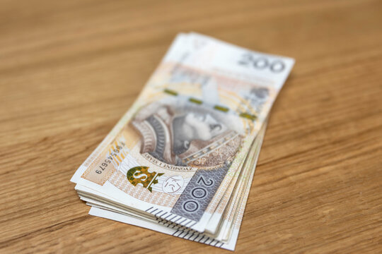 Plik banknot&oacute;w 200 złotych na dębowym stole &mdash; got&oacute;wka, bogactwo, wypłata, Polska