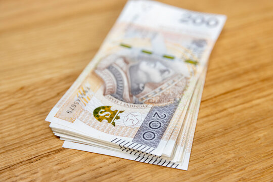 Plik banknot&oacute;w 200 złotych na dębowym stole &mdash; got&oacute;wka, bogactwo, wypłata, Polska
