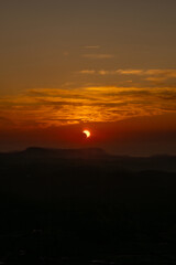 Obraz premium Dramatic partial solar eclipse sunset over the dark mountain landscape of Monte Toro in Menorca, Spain