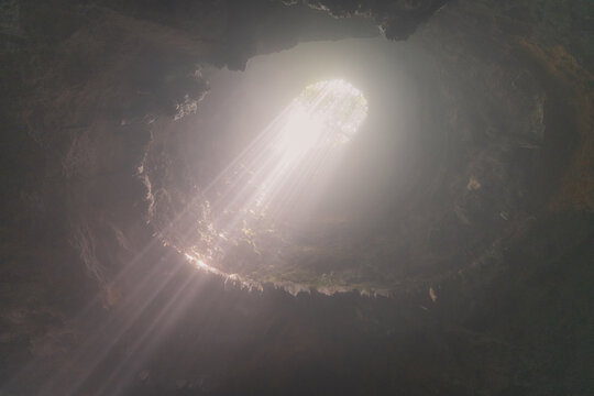 Jomblang cave in Gunungkidul is a doline formed by a cave collapse a large, natural sinkhole with steep edges surrounded by trees. Geological formations and natural land changes.
