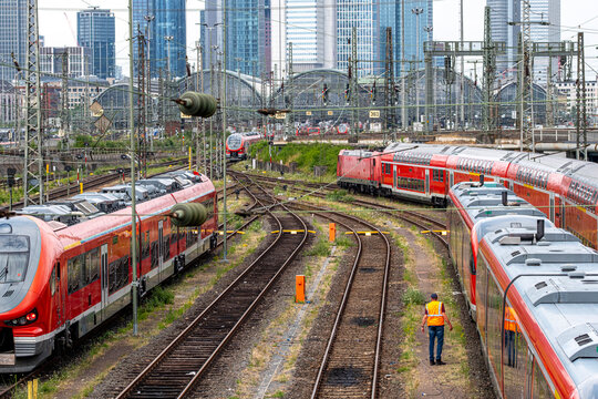 Red train lines move across curving tracks in Frankfurt, where Germany railway infrastructure, station signals and skyline towers shape a dense urban view