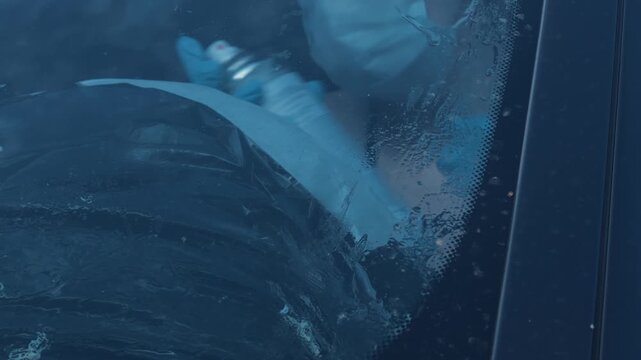 Person Cleaning Car Windshield With Covered Dashboard