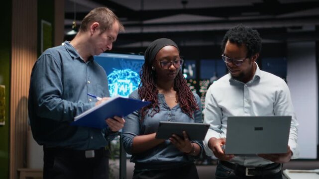 Technology startup coworkers brainstorming ways to optimize performance in office. Team of engineers use machine learning on devices for debugging, typing lines of code for debugging workflows.