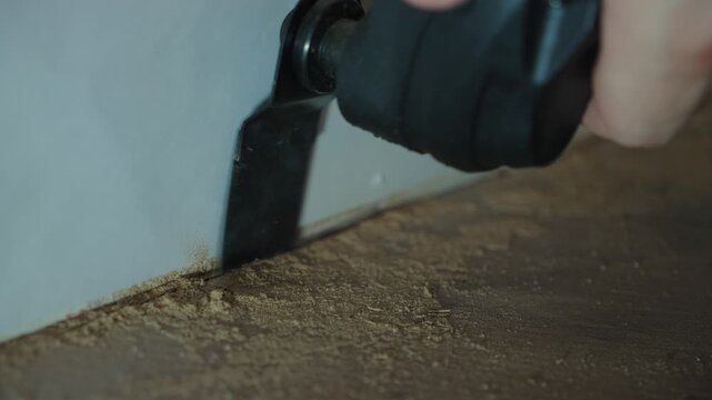 Oscillating Tool Trimming Floor Edge Near Wall