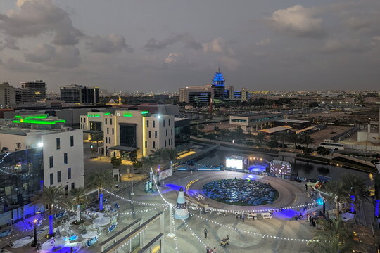An elevated dusk view shows the Live at the Lake outdoor plaza at Dubai Digital Park on 14 December 2023 in Dubai, UAE. Blue beanbags are neatly arranged for an evening community event.