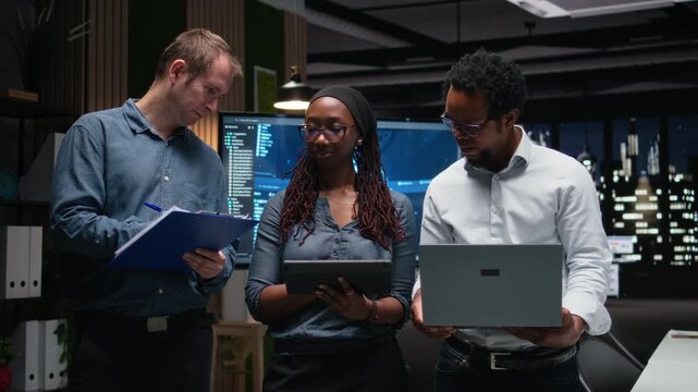 Technology startup coworkers brainstorming ways to optimize performance in office. Team of engineers use machine learning on devices for debugging, typing lines of code for debugging workflows.