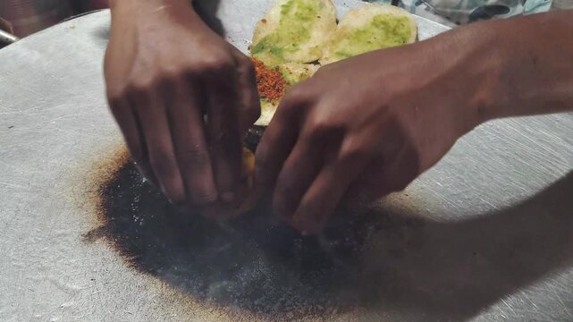 Preparing Spicy Vada Pav on a Street Side Tawa