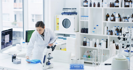 Naklejka na ściany i meble Scientist, woman and inspection in lab with clipboard, sample test or medical research for vaccine. Person, evaluation and science study in clinic with checklist, cure development or healthcare trial