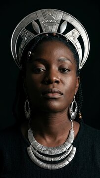 African woman wearing traditional silver jewelry and tribal headdress. Portrait of Black female model in ethnic cultural fashion on dark background
