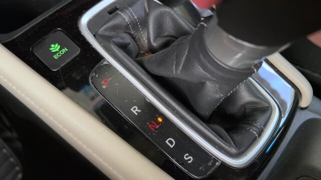 Closeup view of car gear shift changing driving mode inside modern vehicle console with transmission control indicator and transportation technology