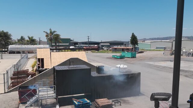 Aerial wide panning shot of dense smoke escaping a flashover fire training module during a live-fire exercise in Ventura County, California. 4K