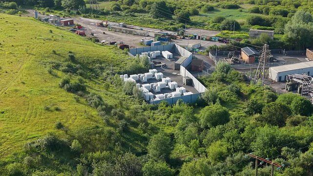 Slow Orbit Aerial of Small Modular BESS Battery Energy Storage System with Lithium-ion Containers. Grid management, AI energy optimization, and sustainable infrastructure. UK. 4K.