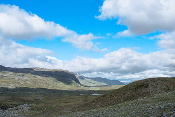 Fototapeta premium Panoramic summer landscape of vast green Sweden Nordic nature with rolling hills and lush arctic tundra meadows under a dramatic blue sky for outdoor adventure and travel background