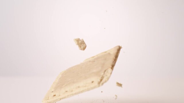 Cinnamon-frosted retro pop tarts dropping and bouncing across white seamless backdrop in high speed slow motion. back to school posts, after school snack videos, kids brand commercials.