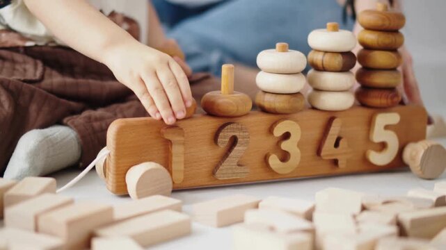 Toddler playing with wooden blocks and numbers, educational toys for children, learning numbers, wooden puzzle