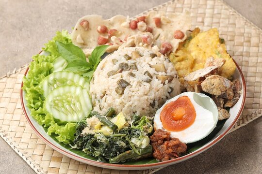 Nasi Megono, a signature dish from Central Java, Indonesia, featuring steamed rice topped with finely chopped young jackfruit mixed with grated coconut and aromatic spices