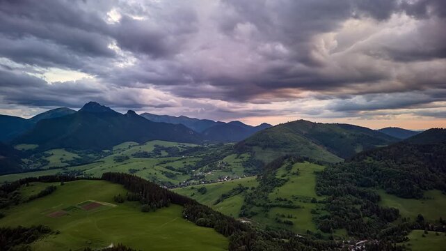 Aerial hyperlapse of a lateral orbit flight over green Carpathian hills at dusk