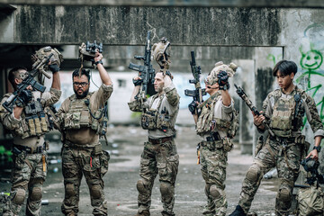 Obraz premium Tactical team celebrates mission success raising helmets and fists together in abandoned building