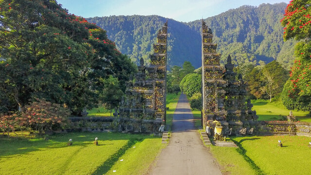 The iconic Handara Gate, a traditional Balinese split gateway surrounded by lush green mountains in Bali, Indonesia.