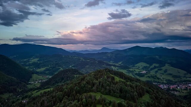 Aerial Hyperlapse Forward Over Forest Toward Mountain Panorama at Dramatic Sunset