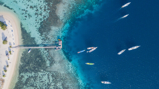 Top Down Aerial View of Wooden Jetty, Sandy Beach and Coral Reef at Kanawa Island