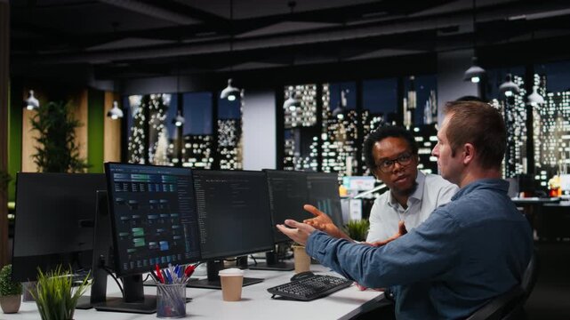 Team of technicians collaborating in office, typing code on computer, developing machine learning models to automate tasks. Employees work together write programming language scripts on PC.