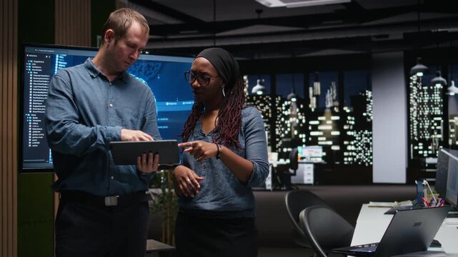 Technicians collaborating to develop artificial intelligence algorithms in high rise office late at night. Tech agency coworkers debug 3D neural network brain models for coding workflows.