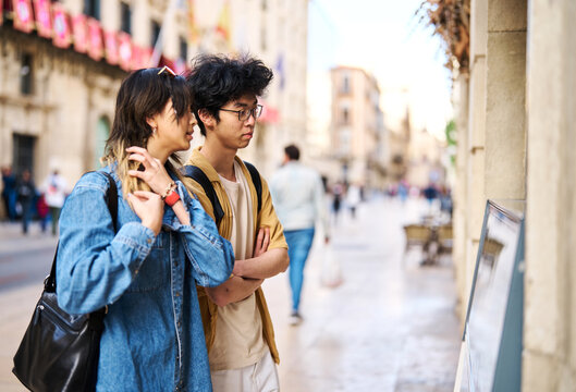 Portrait of a smiling couple in the city, tourists visiting destination, summer trip exploring