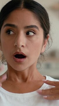 Overheated tired Indian Arabian woman at home waving hand trying to cool down unhappy female sweating suffering high temperature feeling hot air conditioner climate control discomfort indoors problem