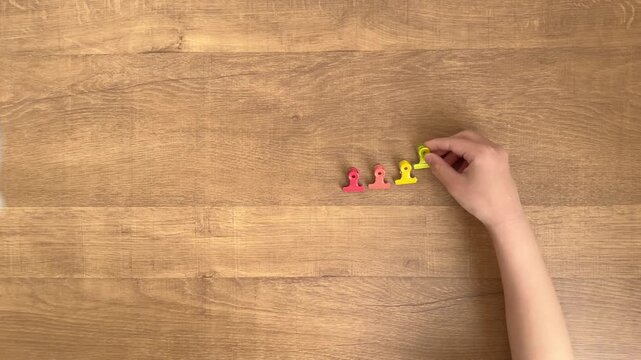 Child Hand Placing a Fourth Light Green Clip in a Row, Top Down View, 4K Silent Video