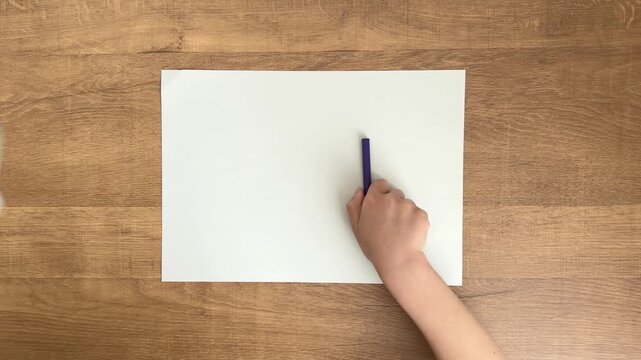 Child Hand Placing a Purple Marker Beside Blank Paper, Top Down View, 4K Silent Video