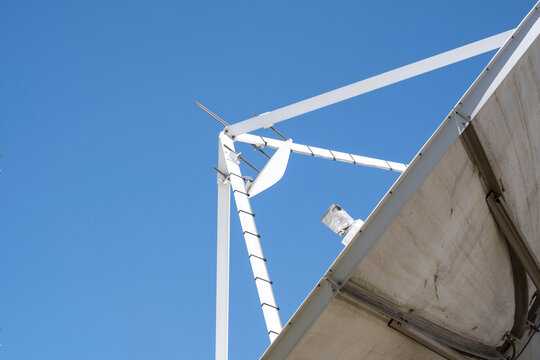 Industrial satellite dish antenna looking up at clear blue sky for telecommunication and broadcasting