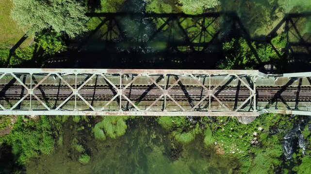 Aerial drone view of railway bridge crossing a river. Train bridge over flowing clean river.