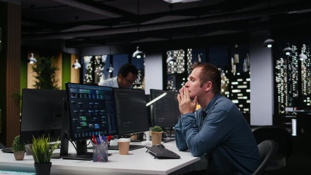 Stressed IT professional in workplace pleased after fixing glitches, doing AI tech quality assurance.