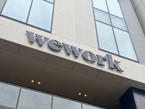 WeWork coworking space company logo and exterior signage on a modern office building facade with glass windows in the city center of Sapporo - Hokkaido, Japan, May 10, 2026