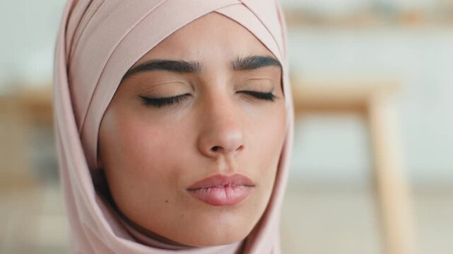 Serious stressed Muslim Arabian woman in hijab pensive worried thinking indoors thoughtful focused young female Islamic girl portrait hesitant problem solution anxiety concerned lady looking away home