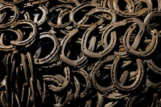 Full frame texture of many rusty antique iron horseshoes