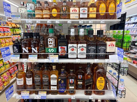 Alcohol department shelves in a Sapporo convenience store featuring Suntory Whiskey, Nikka Black, Jim Beam, and Jack Daniels bottles on display - Hokkaido, Japan, May 09, 2026