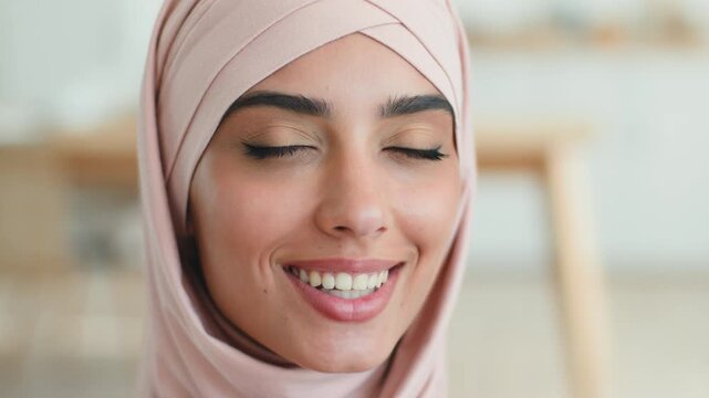 Happy smiling Arabian Muslim woman in hijab talking looking camera positive laughing indoors portrait satisfied cheerful female Islamic girl virtual video call conference online chatting social media