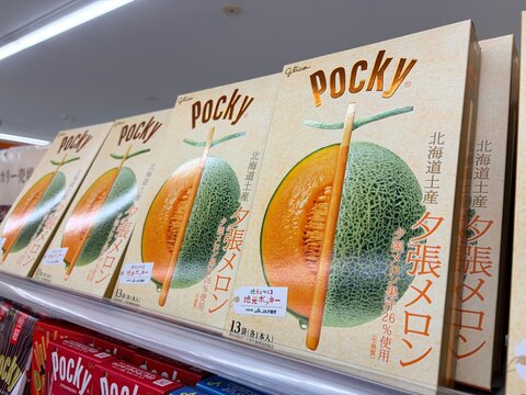 Glico Yubari Melon Pocky souvenir boxes displayed on a shop shelf featuring Hokkaido regional specialty snack packaging with fruit illustration - Hokkaido, Japan, May 9, 2026