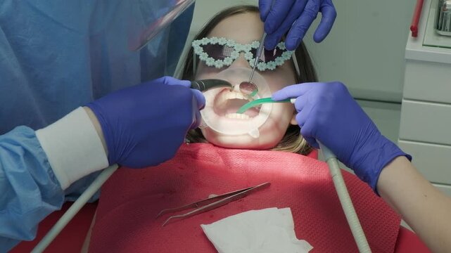Dentist team performing medical dental procedure on child patient