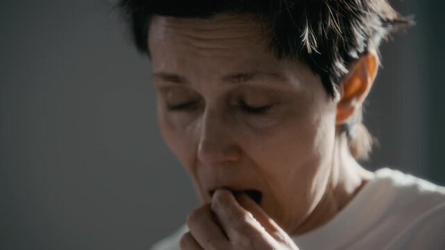 Tilt up of middle aged Caucasian woman taking capsule pill from container and drinking water from glass. Clip is perfect for mental health awareness campaigns and pharmaceutical advertisements